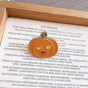 Dettaglio ravvicinato di una simpatica spilla di Halloween a zucca in smalto e metallo