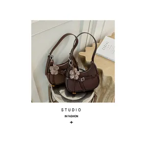 Bolsos de hombro vintage marrones con colgantes de flores en taburete de metal