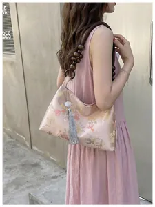 Detailed view of Neo-Chinese floral satin hobo bag with wooden bead strap and tassel