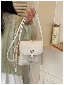 Elegant houndstooth patterned crossbody bucket bag with a golden heart buckle detail