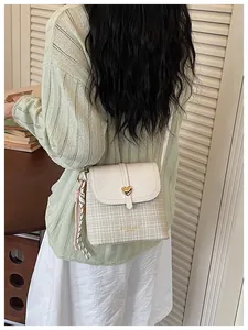 Stylish plaid bucket bag for women featuring a gold heart clasp detail and scarf
