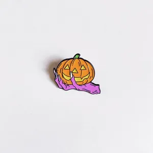 Close-up detail of a vibrant Halloween enamel pin featuring a monster hand holding a pumpkin