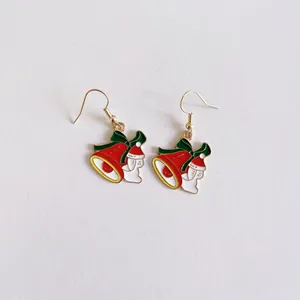Vista detallada de lindos pendientes festivos de esmalte de campana y Papá Noel