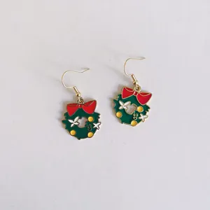 Vista detallada de pendientes de esmalte de corona de Navidad con lazos rojos en blanco