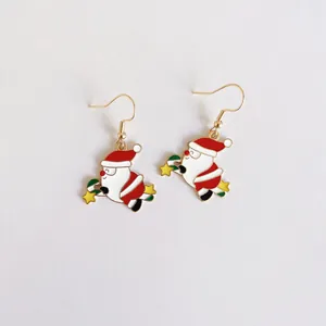 Primer plano detallado de los lindos pendientes de esmalte de Papá Noel para Navidad
