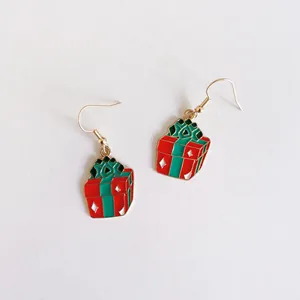 Vista detallada de los pendientes de regalo de Navidad con acabado en esmalte rojo y verde.