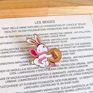 Detail of cute rabbit enamel pin holding a mooncake for Mid-Autumn Festival