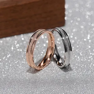 Close-up of frosted texture on minimalist titanium steel rings in rose gold and silver