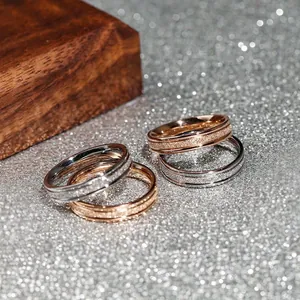 Macro view of minimalist frosted titanium steel rings in rose gold and silver finishes.