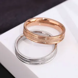 Detail view showing the elegant frosted texture of rose gold and silver titanium rings