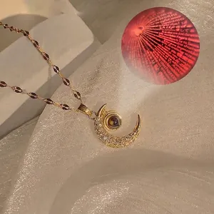 Close-up detail of moon projection necklace showing 'I love you' in 100 languages