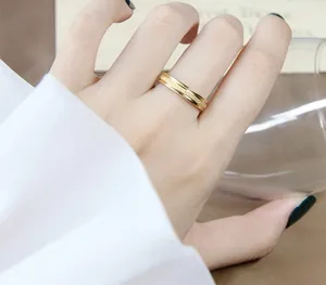 Close-up of minimalist frosted rose gold titanium steel ring on hand, showing fine texture.