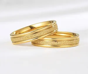Detailed macro view showing the textured frosted surface of minimalist gold titanium rings