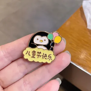 Macro view of a cute penguin enamel pin with balloons and festive Chinese text decoration