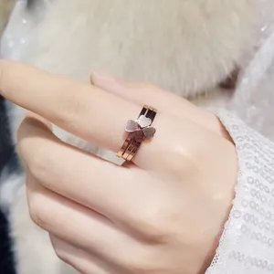 Gros plan d'une élégante bague trèfle empilable trois-en-un en or rose au doigt