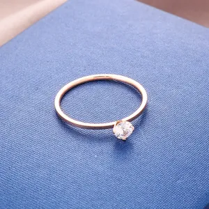 Close-up of a minimalist rose gold titanium steel ring with a single zircon stone.