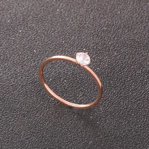 Detailed view of a delicate rose gold titanium steel ring with a single cubic zirconia stone.