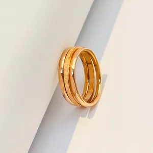 Close-up of minimalist rose gold triple-interlocking ring with a frosted band texture.