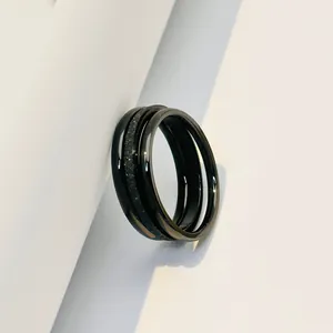 Close-up of black titanium steel ring featuring frosted and polished triple bands