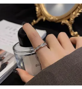 Close-up of a full diamond eternity ring worn on a woman's index finger in a lifestyle shot