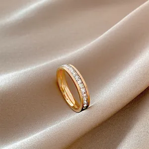 Detailed macro close-up of a sparkling rose gold eternity ring on elegant beige silk fabric