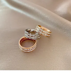 Close-up of three sparkling full-diamond eternity rings in gold and silver on silk