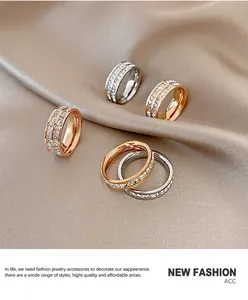 Detailed view of titanium steel rings with double-row sparkling crystals on silk fabric.