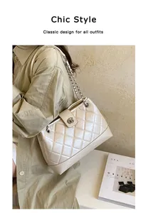 Beigefarbene gesteppte Ketten-Schultertasche an einem Modell mit grünem Trenchcoat