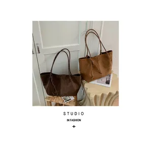 Close-up view showing the rich suede texture of brown and tan vintage tote bags