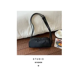 Close-up of a vintage black nylon crossbody bag arranged with lifestyle accessories.