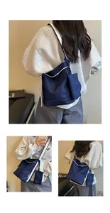 Detail view of navy blue canvas tote bag with white trim and matching pouch