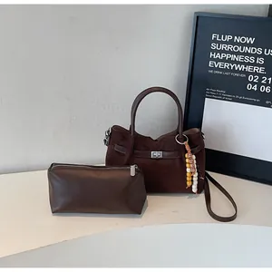 Detail view of dark brown suede tote bag with matching leather pouch set