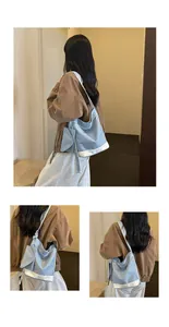 Detailed view of the large blue canvas tote bag with white trim and extra small pouch