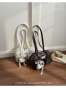 Detail view of two vintage-style polka dot shoulder bags with elegant pearl charms