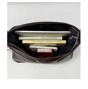 Interno spazioso della borsa tote in pelle vintage con laptop e libri personali