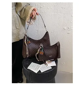 Vista dettagliata di un set di borse hobo intrecciate marroni con nappine chic