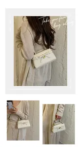 Detailweergaven van een minimalistische off-white handtas met krokodillenpatroon en strik.