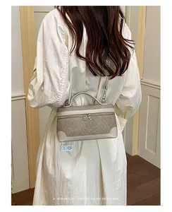 Gedetailleerde opname van een elegante beige linnen vanity bag met crèmekleurig leer