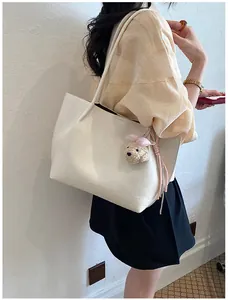 Detailed shot of cream white large capacity tote bag with cute pink plush puppy charm