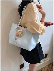 Stylish light blue leather tote bag for women with cute plush bear charm detail
