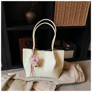 Elegant cream faux leather tote bag for women featuring a cute teddy bear charm accessory