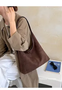 Große braune Tragetasche aus Wildleder für Damen im Maillard-Stil am Model