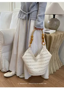 White hollow-out tote bag with unique wooden bead handle in a minimalist setting.