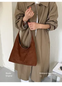 Modische braune Wildleder-Hobo-Tasche an einem Modell für einen schicken Maillard-Look.