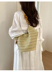 Detailed view of hollow-out tote bag with wooden bead strap and minimalist design