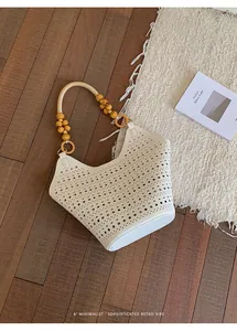 Minimalist white perforated tote bag with elegant wooden bead handle on a rustic floor
