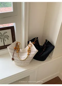 Close-up of minimalist hollow-out tote bags with retro wooden bead handle decorations.