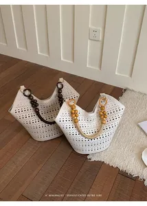 Detailed macro shot of two white hollow-out tote bags featuring wooden bead handles