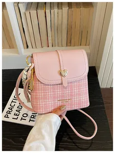 Elegant pink tweed crossbody bucket bag featuring heart buckle and silk scarf charm