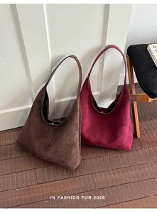 Zwei Vintage Wildleder Hobo Taschen in Braun und Burgund lehnen an einer Wand